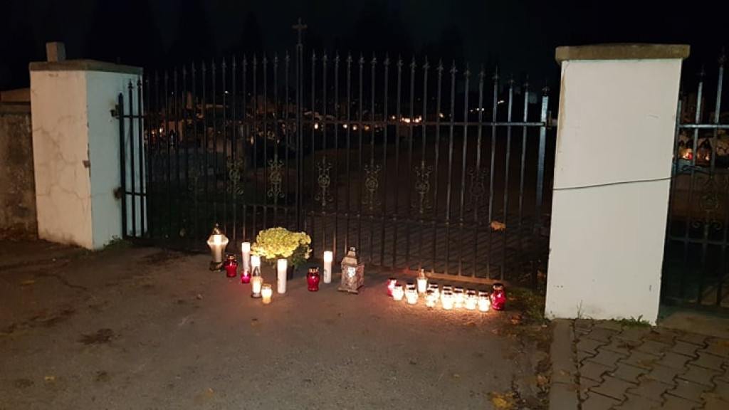 Znicze i kwiaty na murach cmentarza i pod biurem posła PiS [zdjęcia]