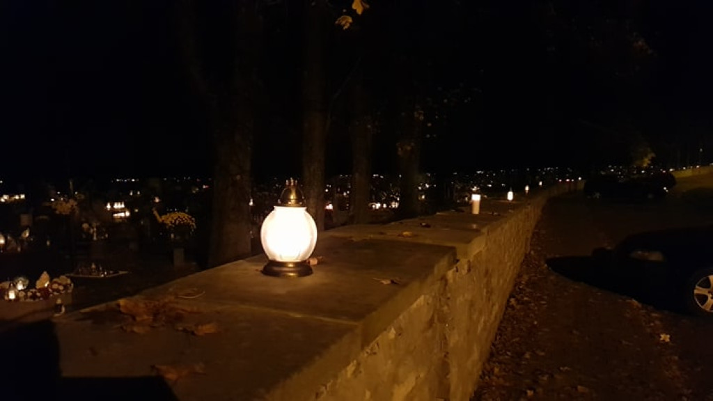 Znicze i kwiaty na murach cmentarza i pod biurem posła PiS [zdjęcia]