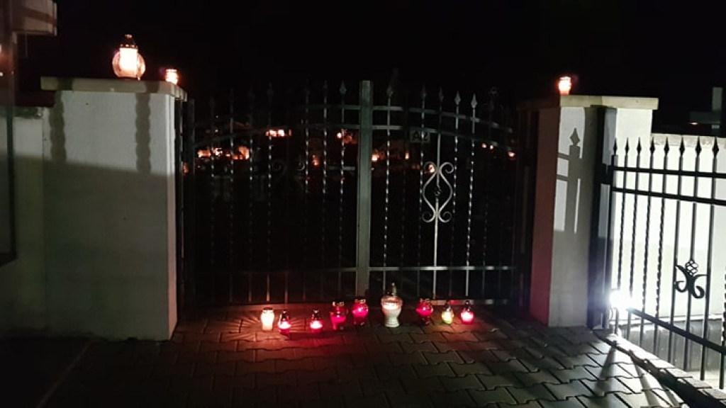 Znicze i kwiaty na murach cmentarza i pod biurem posła PiS [zdjęcia]
