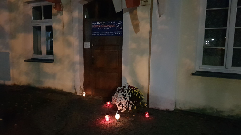 Znicze i kwiaty na murach cmentarza i pod biurem posła PiS [zdjęcia]