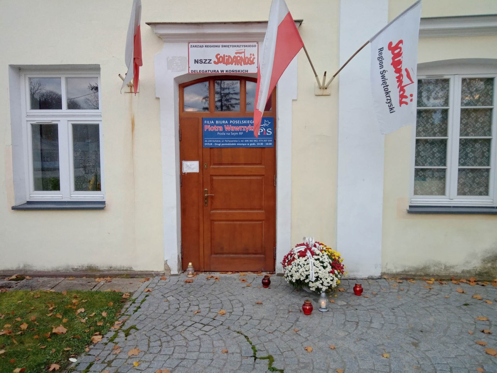 Znicze i kwiaty na murach cmentarza i pod biurem posła PiS [zdjęcia]